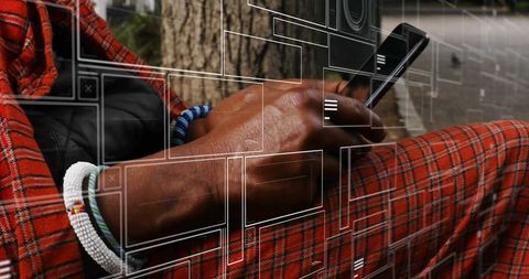 Tribal attire and technology: checking smartphone outdoors