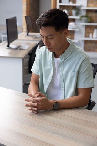 Contemplative Man in Modern Office Focusing at Desk