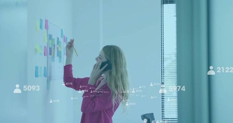 Businesswoman Collaborating on Office Wall with Analytics Overlay