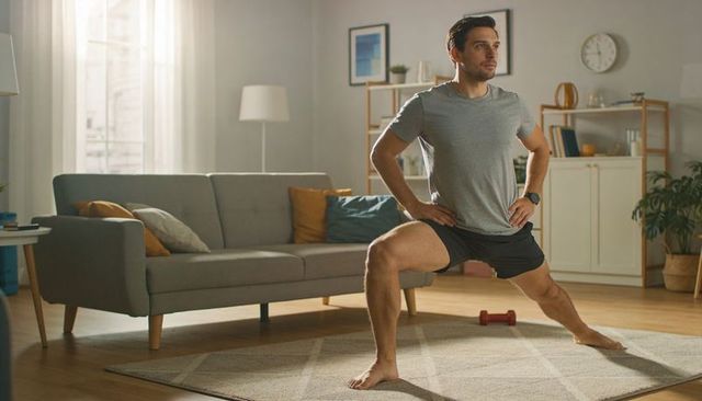 Man performing lateral lunge in bright living room for home workout and strength training