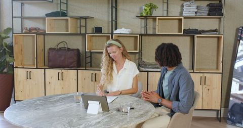 Diverse Colleagues Collaborating with Tablet at Round Office Table