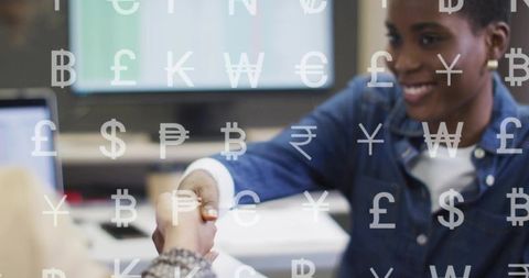 Smiling woman shaking hands across desk with currency symbols overlay for fintech