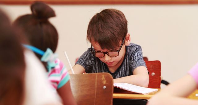 Focused Young Boy Writing in Classroom - Download Free Stock Images Pikwizard.com