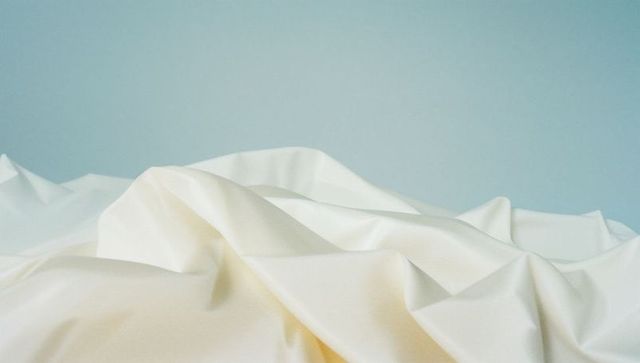 Elegant draped fabric against pastel blue backdrop