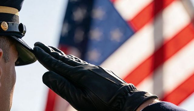 Uniformed officer saluting with leather glove before american flag, patriotic tribute
