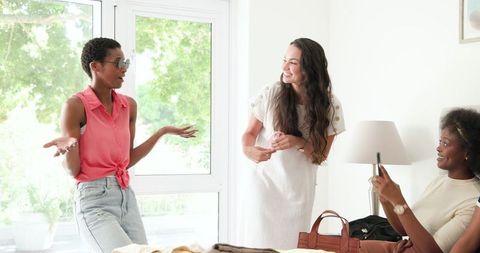 Friends Enjoy Laughter and Capture Moments in Bright Home Environment