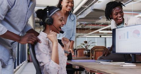 Excited Team Celebrating Success with High Fives in Modern Office