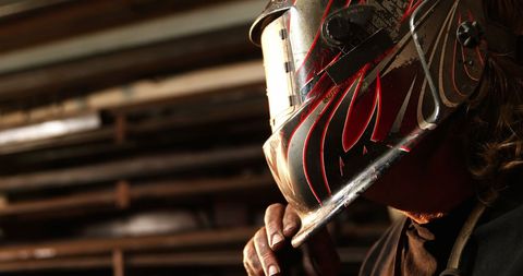 Focused Welder with Stylish Helmet in Industrial Workshop
