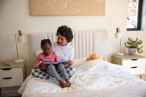 Mother and Daughter Reading Together in Cozy Bedroom