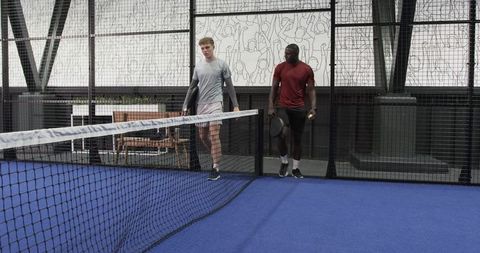 Diverse Male Friends Engaging in Paddle Tennis on Modern Court