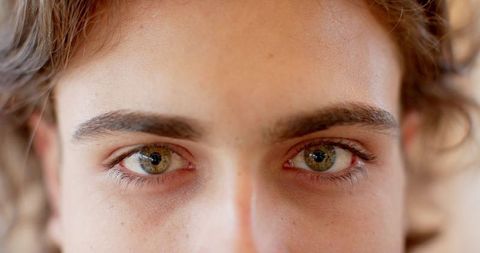 Close-Up Portrait of Young Woman Showcasing Hazel Eyes and Skin Texture