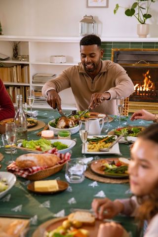 Family Enjoys Roast Turkey in Cozy Dining Room During Festive Meal