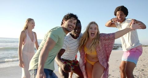 Diverse Friends Enjoying Laughter at the Beach in Sunny Weather