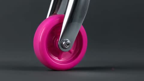 Close-up pink caster wheel rotating on chrome fork for product demo studio video