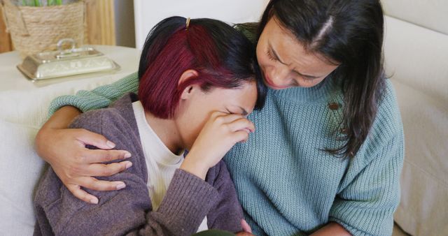 Biracial sisters sitting on sofa, crying and embracing, in slow motion - Download Free Stock Photos Pikwizard.com