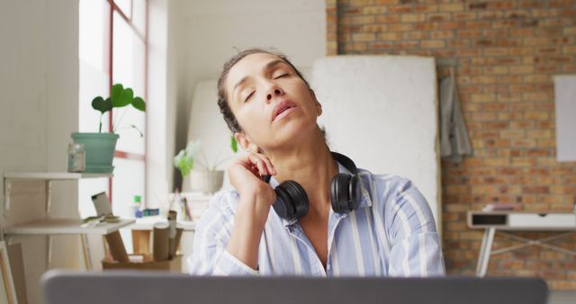 Tired Woman with Headphones Taking a Break in Modern Office - Download Free Stock Images Pikwizard.com