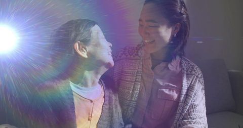 Grandmother and Granddaughter Sharing Joy in Living Room, Lens Flare Effect