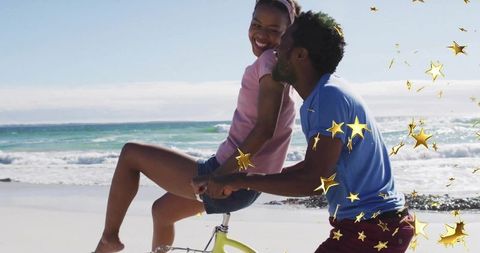 Joyful Couple Enjoying Fun Bicycle Ride on Sunny Beach