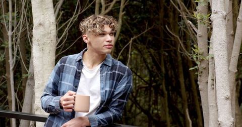 Man Relaxing with Coffee Mug in Wilderness