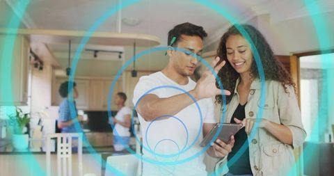 Couple collaborating with tablet using augmented reality overlays in modern openplan kitchen