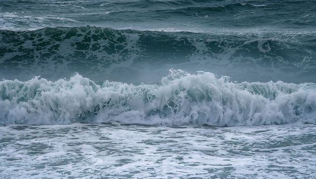 Powerful ocean waves crashing in coastal surf, frothy white breakers, deep teal swells and spray