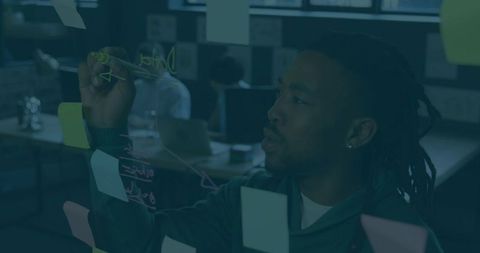 Focused Professional Planning on Glass Board in Modern Office