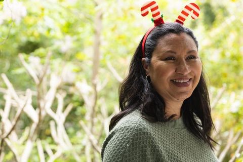 Festive woman outdoors wearing candy cane antler headband