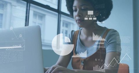 Woman Typing at Office Desk with Data Analysis Graphics