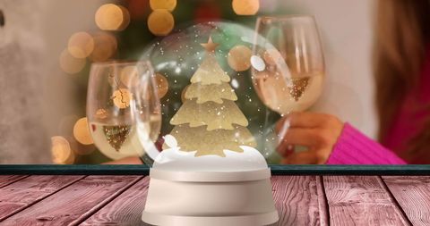 Festive Snow Globe with Christmas Lights and Champagne Glasses