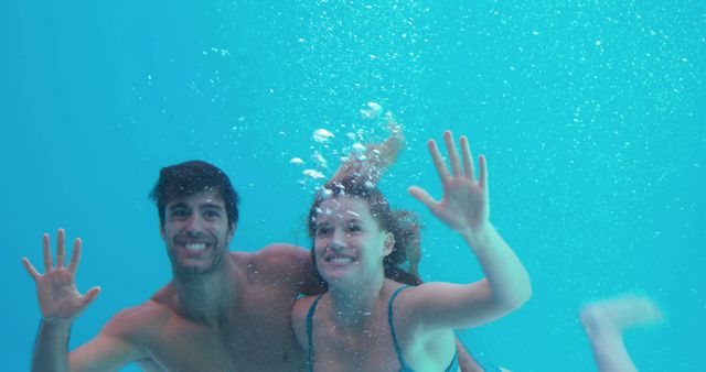  Happy couple swimming underwater on holidays