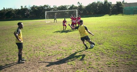 Young Soccer Players Taking Free Kick on Community Field