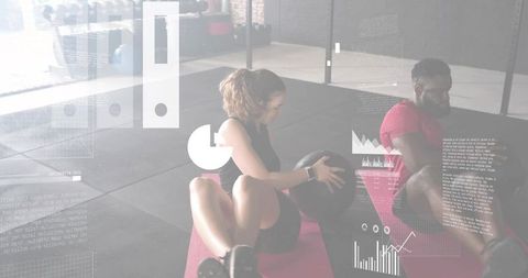 Partners performing medicine ball rotation on pink mats in gym with fitness data overlays