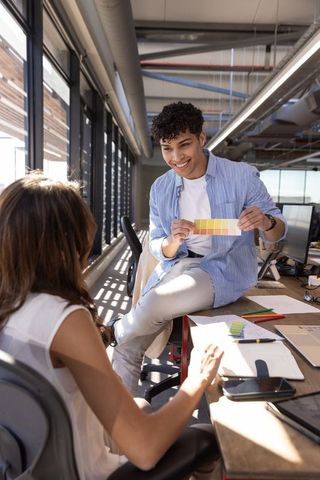 Colleagues discussing color palette in modern design office