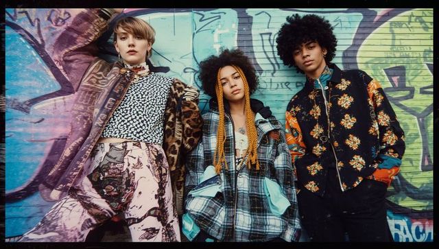 Trio of Models Showcasing Vibrant Streetwear Against Graffiti Wall