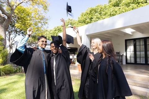 Graduates Celebrating Success Outdoors with Cap Tossing