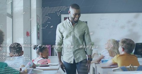 Smiling male teacher walking among elementary students, fostering classroom engagement