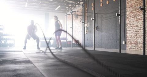 Partners engaging in high-intensity battle rope workout