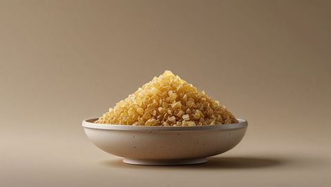 Heap of raw frankincense crystals in ceramic bowl on neutral background