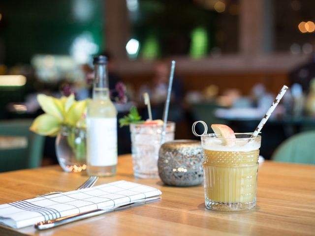 Refreshing cocktails with straws on wooden table in a cozy cafe. Ideal for illustrating dining experiences, relaxation, hospitality, restaurants, or social gatherings.