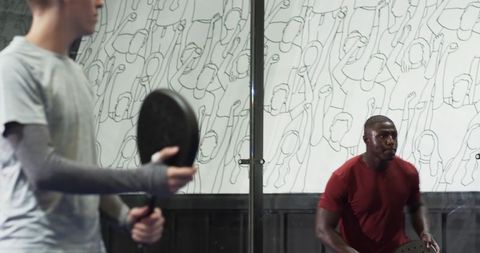 Diverse players engaging in indoor pickleball duel