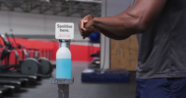 Man Using Hand Sanitizer Station in Gym - Download Free Stock Images Pikwizard.com