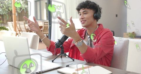 Recording podcast at home with laptop and microphone, young host wearing headset gesturing