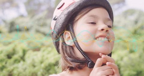Smiling child fastening bicycle helmet strap with colorful waveform overlay for safety