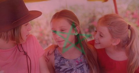 Three girls hugging on garden bench under canopy, laughing and enjoying sunny friendship