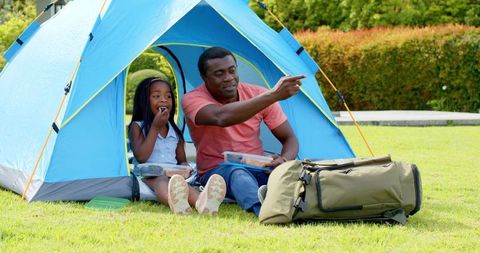 Father and Daughter Bonding Outdoors in Blue Tent Adventure