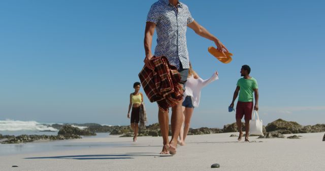 Group of Friends Walking on Sandy Beach with Towels and Shoes - Download Free Stock Images Pikwizard.com