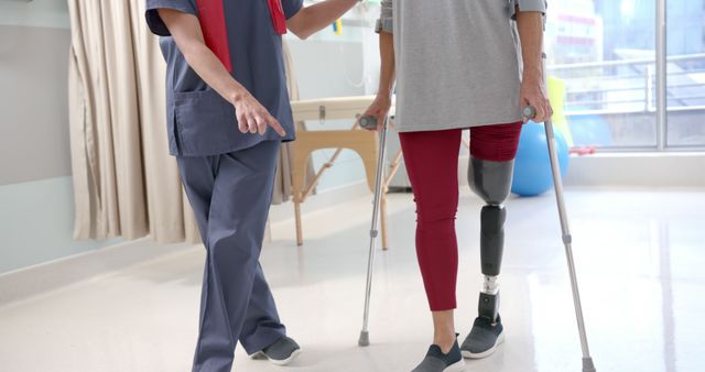 Depicts a physical therapist assisting a patient with a prosthetic leg. Useful for medical and health-related content, rehabilitation guides, or services promoting physical therapy and patient recovery.