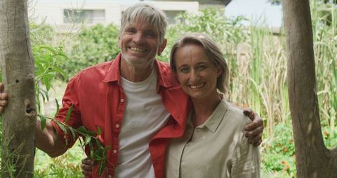 Smiling Senior Couple Embracing in Lush Green Garden