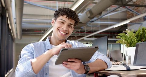 Happy Man Using Tablet in Modern Office Environment