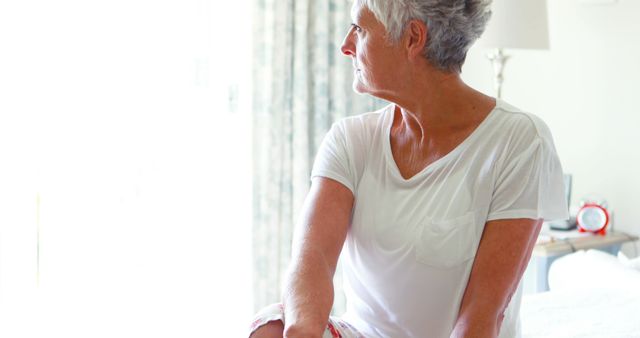 Senior Woman Sitting in Bedroom Looking Out Window - Download Free Stock Images Pikwizard.com